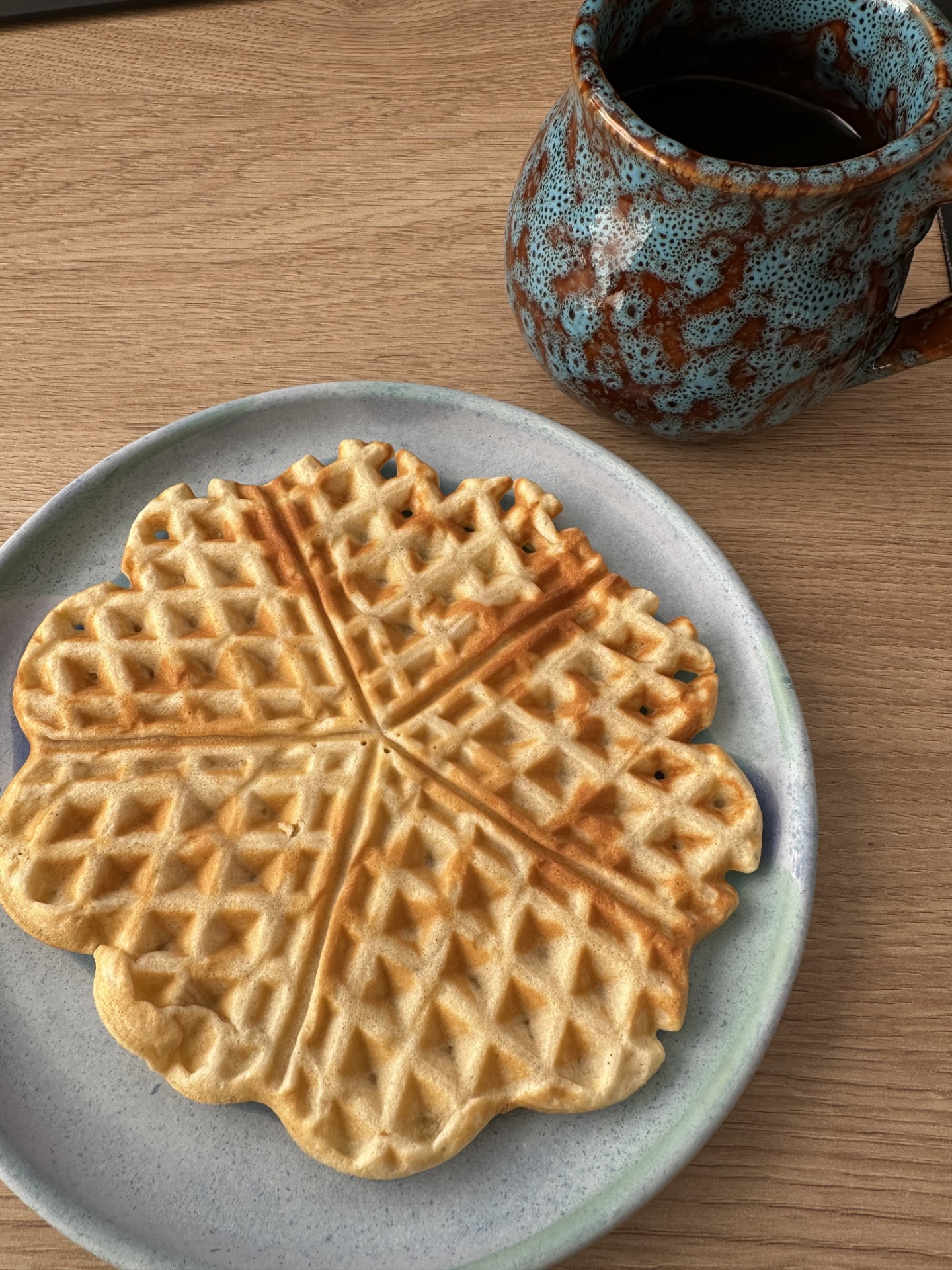 Selbst gebackene norwegische Herzwaffel mit einer Tasse Kaffee